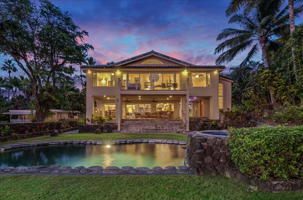 The main house at dusk above the pool